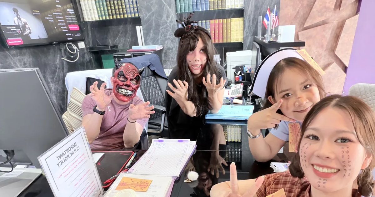 Maximum Clinic Bangkok front desk team in Halloween costumes, posing playfully